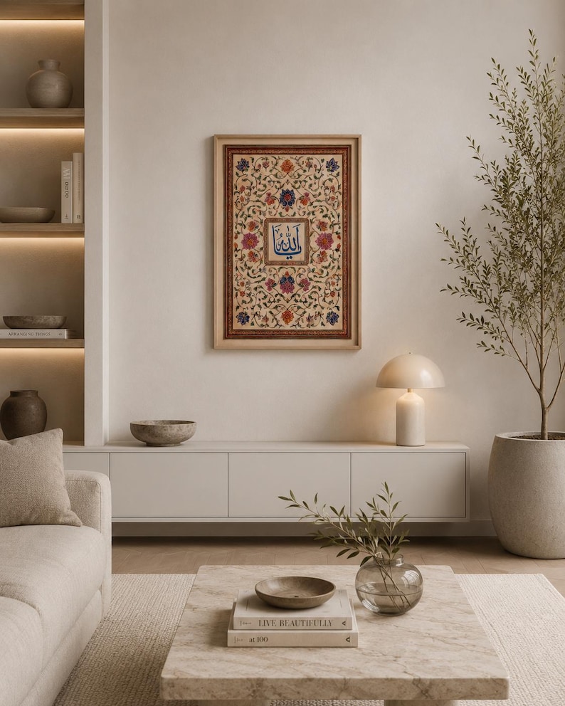 May include: A rectangular framed wall art piece featuring intricate floral patterns in shades of red, blue, and green surrounding a central square panel with blue Arabic calligraphy. The artwork is enclosed in a light-toned wooden frame.