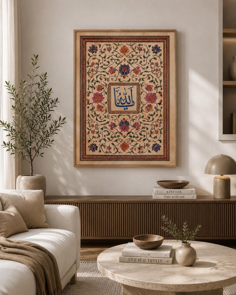 May include: A rectangular framed wall art piece featuring a central blue Arabic calligraphy script surrounded by an intricate, symmetrical floral pattern in shades of pink, orange, and blue on a cream background, enclosed in a light wood frame.