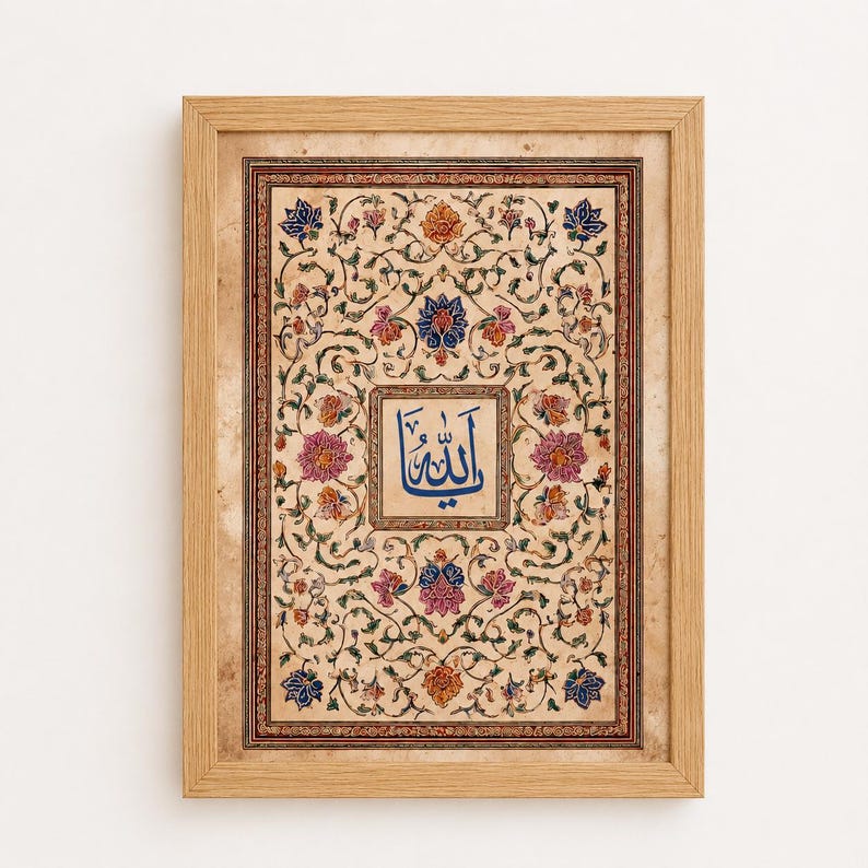 May include: A framed rectangular wall art piece featuring a central blue Arabic calligraphy script surrounded by intricate floral patterns in shades of pink, orange, and blue on a beige parchment-style background, enclosed in a light wood frame.