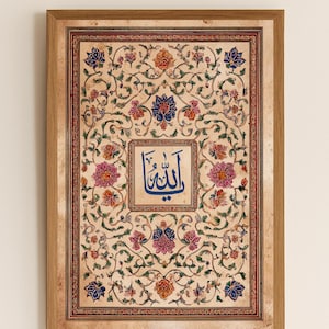 K&ouml;nnte beinhalten: Gerahmtes Kunstwerk mit detailliertem Blumenmuster in Beige-, Rot-, Blau- und Rosat&ouml;nen. Das Kunstwerk enth&auml;lt ein zentrales Quadrat mit blauer arabischer Kalligraphie. Der Rahmen besteht aus hellbraunem Holz.