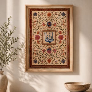 May include: A rectangular framed wall art piece featuring intricate floral patterns in shades of pink, orange, and blue on a cream background. A central square contains blue Arabic calligraphy. The frame is a light-toned wood with a thin border.