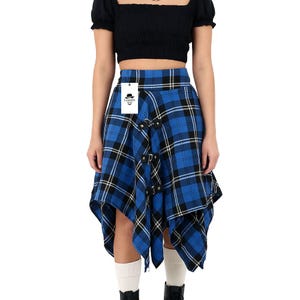 May include: Blue plaid skirt with black and yellow accents. The skirt features a unique asymmetrical design with metal hardware and a tag that reads "FASHION". The skirt is a stylish addition to any wardrobe.