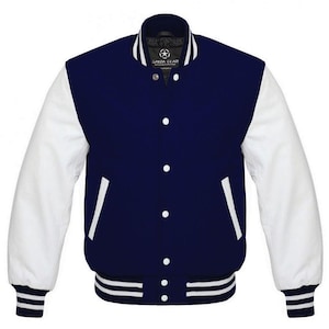 Puede incluir: Chaqueta universitaria azul marino y blanca con mangas blancas, cuerpo azul marino y detalles blancos. La chaqueta tiene cierre de botones, dos bolsillos delanteros y puños y dobladillo a rayas. La marca "SAIDA GEAR" es visible.