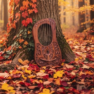 Può includere: Una lira in legno con disegni floreali intagliati, appoggiata a un tronco d'albero in un ambiente forestale. Lo strumento ha più corde ed è circondato da foglie autunnali colorate in tonalità rosse, arancioni e gialle.