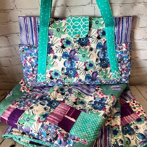 May include: A teal and purple patchwork quilt with a floral print and a matching teal tote bag with white polka dots.