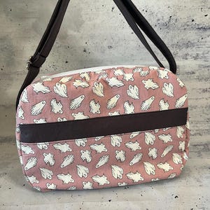 Bandolera con diseño de fantasma que brilla en la oscuridad, con bolsillos con cremallera para guardar cosas