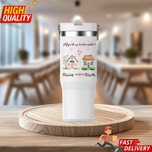 May include: A white insulated travel mug with a silver rim and a grey lid. The mug has a design with two houses, hearts, and the text "Will you be my hearts neighbour?" and the names "Olivia" and "Oliver".