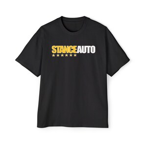 May include: A black short-sleeve t-shirt featuring the text STANCEAUTO printed across the chest. The word STANCE is in yellow, and the word AUTO is in white. Below the text are six yellow stars arranged in a horizontal row on the front.