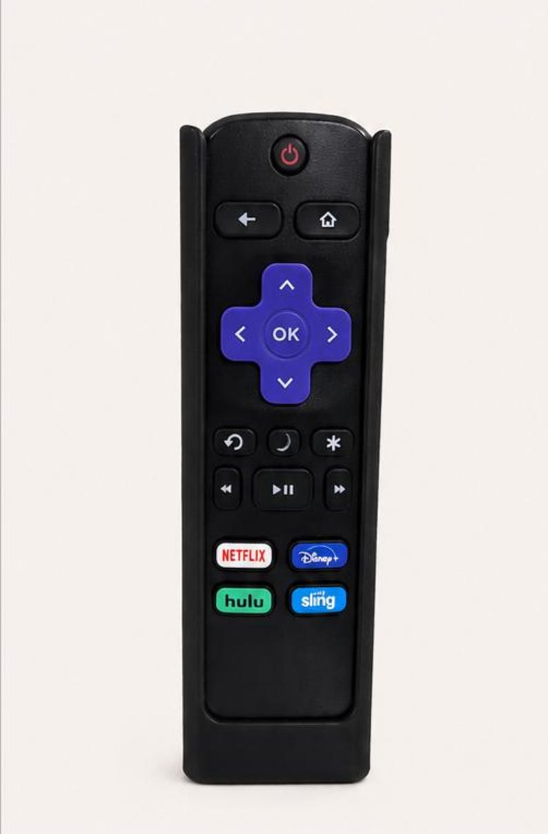 Pu&ograve; includere: Un telecomando nero dotato di un pad direzionale viola con un tasto OK al centro. Il dispositivo include un tasto di accensione rosso, icone di navigazione e quattro tasti dedicati ai servizi di streaming etichettati Netflix, Disney+, Hulu e Sling.