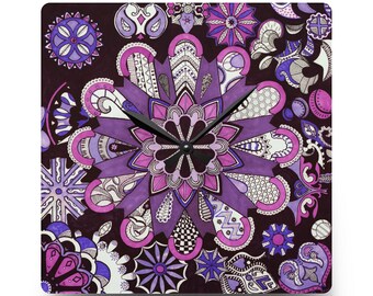 May include: Square wall clock with a purple and white floral mandala design. The clock face features a dark brown background with various purple and pink floral patterns. Black clock hands indicate the time.