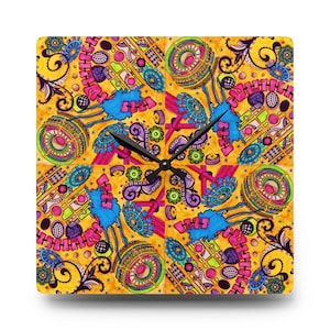 Puede incluir: Reloj de pared cuadrado con un diseño abstracto vibrante. La esfera del reloj presenta un fondo amarillo con un patrón repetitivo de formas azules, rosas, verdes y moradas. Las manecillas negras indican la hora.