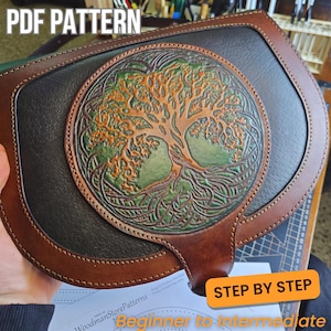 Peut inclure: Sac en cuir artisanal avec un motif d'arbre de vie détaillé en relief sur le devant. Le sac présente une combinaison de cuir marron, vert et noir, avec le texte "PDF PATTERN" et "STEP BY STEP" visible.
