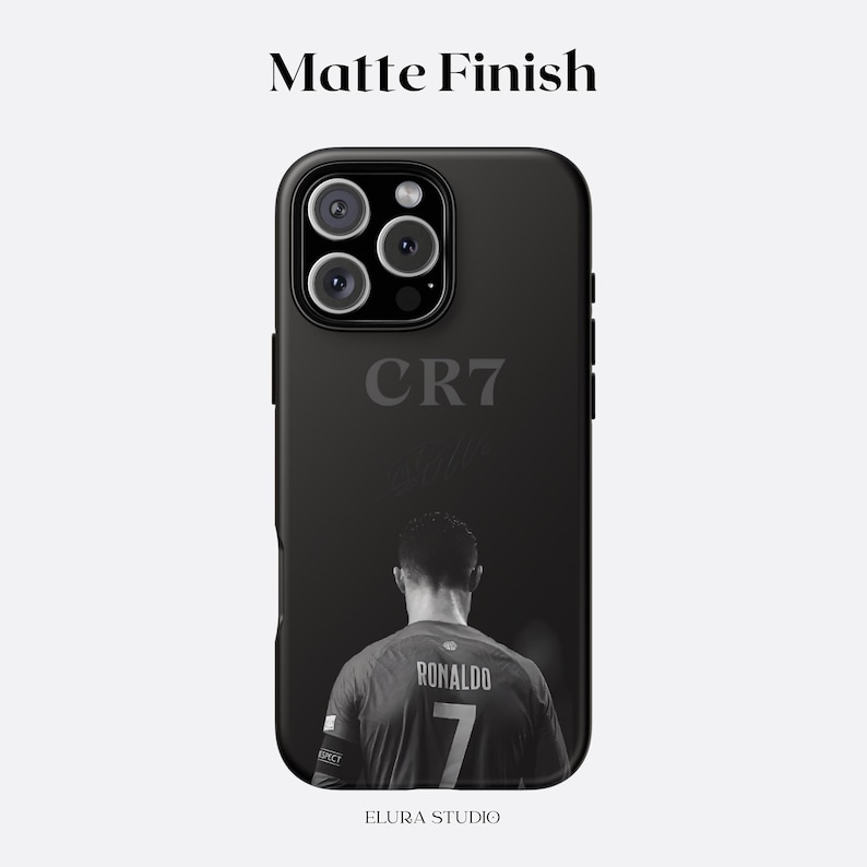 K&ouml;nnte beinhalten: Schwarze, matte Handyh&uuml;lle mit einem Graustufenbild eines Fu&szlig;ballspielers, der "Ronaldo" und die Nummer "7" auf dem Trikot zeigt. Die H&uuml;lle zeigt auch den Text "CR7" und "ELURA STUDIO".