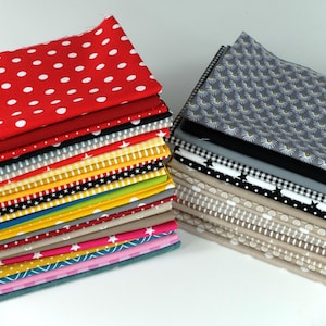Könnte beinhalten: Zwei Stapel gemusterter Stoffquadrate. Ein Stapel zeigt roten Stoff mit weißen Punkten. Weitere Stoffe umfassen Muster mit Sternen, Streifen und floralen Designs. Die Stoffe sind in verschiedenen Farben erhältlich, darunter Rot, Gelb, Schwarz, Grau und Rosa.