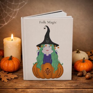 May include: A hardcover book with a cream-colored cover titled Folk Magic. The cover features an illustration of a person with long green hair wearing a black pointed hat, resting their chin on their hands while emerging from a large orange pumpkin.