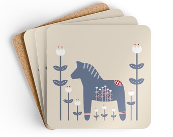 May include: A set of square coasters with a cork backing and a beige top surface. The design features a blue Dala horse illustration centred between stylised blue and white floral stalks, with small red accents on the horse and flowers.