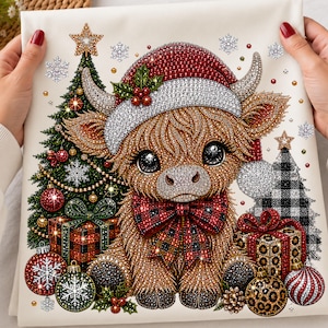 May include: A diamond painting craft featuring a fluffy brown highland cow wearing a red and white Santa hat and a red and black plaid bow. The scene includes a decorated Christmas tree, wrapped gifts, and ornaments on a white background.
