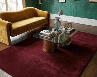 May include: Interior shot featuring a mustard-yellow sofa, a glass coffee table, and a deep red rug. The walls are dark green, adorned with framed pictures and a gold mirror. The rug measures approximately 200cm x 300cm.