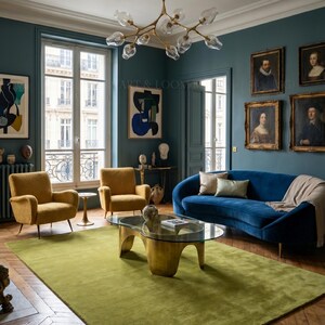 May include: A living room with a green rug, blue sofa, and two yellow armchairs. The room has a gold coffee table, artwork, and a chandelier. The walls are teal, and the floor is hardwood.