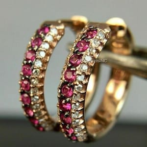 Peut inclure: Boucles d'oreilles créoles en or rose ornées de rangées alternées de pierres précieuses roses vives et de diamants blancs étincelants. Les boucles d'oreilles ont une forme de créole classique, offrant une touche d'élégance.