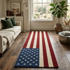 Puede incluir: Una alfombra rectangular con un diseño que se asemeja a la bandera estadounidense. La alfombra presenta rayas rojas y blancas alternas, con un cuadrado azul en la esquina lleno de estrellas blancas. La alfombra está colocada sobre un suelo de madera.