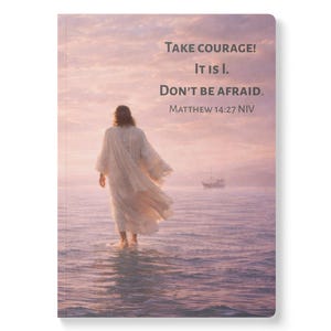 May include: A rectangular notebook featuring a printed image of a person in a long white robe walking on water at sunset. The text reads: Take courage! It is I. Don't be afraid. Matthew 14:27 NIV. A small boat is visible in the distance.