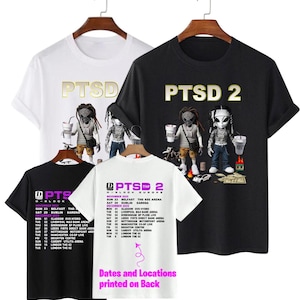 Może przedstawiać: Cztery koszulki na wieszakach, każda z innym wzorem. Koszulki są białe, czarne i czarno-białe. Przód koszulek ma napis "PTSD" lub "PTSD 2" z grafiką. Tył jednej koszulki ma daty trasy.