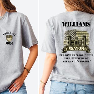 May include: A gray t-shirt with the text "PROUD AIT MOM" on the front and "WILLIAMS" and military-themed graphics on the back. The back also includes "ESSAYONS" and "FT.LEONARD WOOD 2026 35TH ENGINEER BN DELTA CO 'SAPPERS'".