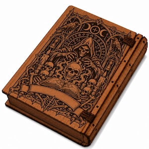 May include: A rectangular wooden box with a hinged lid featuring a laser-engraved design of a hooded skeleton figure, multiple skulls, an open book, hourglasses, and ravens. The artwork includes intricate scrollwork and a blank banner.