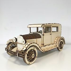 Könnte beinhalten: Ein Holzmodell eines Oldtimers mit hellbeigem Karosserie und dunkelbraunen Akzenten auf der Motorhaube. Das Auto hat detaillierte Räder und Scheinwerfer und zeigt ein klassisches Automobildesign. Das Modell ist aus Holz gefertigt.