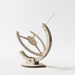May include: A wooden sundial model, featuring a circular design and a central pointer. The sundial has a light brown colour with darker brown accents, set against a white background. The model is a decorative item, measuring approximately 20 cm in height.