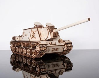 Könnte beinhalten: Ein Holzmodell eines Panzers mit langem Lauf, das detailliert gearbeitet ist. Der Panzer besteht aus hellem Holz mit dunkleren braunen Akzenten, einschließlich der Ketten und verschiedener mechanischer Komponenten. Das Modell spiegelt sich auf einer glänzenden Oberfläche.