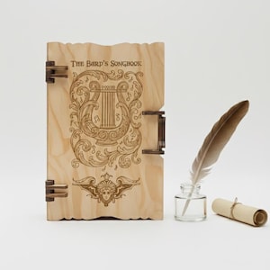 May include: A wooden book titled "The Bard's Songbook" with ornate engraved designs and metal hinges. A feather quill, inkwell, and rolled parchment are next to the book. The book's cover features a harp and scrollwork.