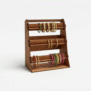 May include: A wooden jewelry display stand with three levels, holding various colorful bangles. The stand is made of light brown wood and has a handle at the top. The bangles are in shades of gold, green, pink, and red.