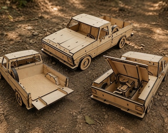 May include: Three light-coloured wooden model pickup trucks. One truck is shown from the front, one with an open tailgate, and one with an open bonnet revealing engine details. Each model features intricate laser-cut panels and circular wheels.