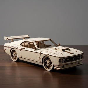 May include: A light-colored wooden model car with a spoiler and detailed wheels. The car has a hood scoop and is set on a dark wooden surface. The model is a replica of a classic sports car.