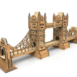 Peut inclure: Maquette en bois du Tower Bridge de Londres. Le modèle est en bois brun clair avec des détails découpés complexes. Le pont a deux tours reliées par une passerelle et une conception de pont suspendu.