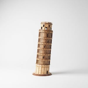 Op de afbeelding: Een houten model van de scheve toren van Pisa. Het model is gemaakt van lichtbruin hout en toont de karakteristieke helling van de toren. Het model bevat gedetailleerde architectonische elementen, zoals ramen en bogen.