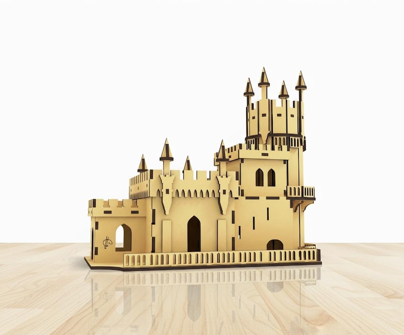 Pu&ograve; includere: Modello in legno dettagliato di un castello con pi&ugrave; torri, porte ad arco e una ringhiera decorativa. Il modello &egrave; realizzato in legno marrone chiaro con dettagli marrone scuro, su una superficie di legno.