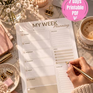Può includere: Un foglio di pianificazione settimanale bianco con il testo MY WEEK Planning, che presenta sezioni dal lunedì alla domenica, un'area di focus, obiettivi e una lista di cose da fare. La carta ha accenti beige ed è scritta con una penna dorata.