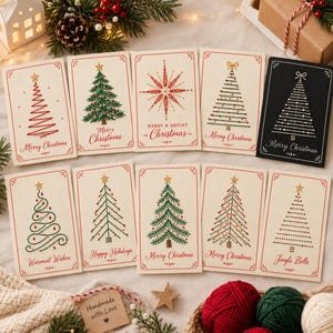 May include: A collection of ten rectangular greeting cards featuring embroidered Christmas tree designs and festive text including Merry Christmas, Merry & Bright, Warmest Wishes, Happy Holidays, and Jingle Bells, displayed on a neutral surface.