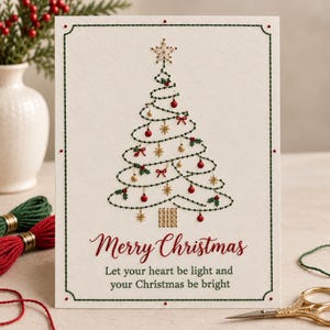 Op de afbeelding: Een crèmekleurige wenskaart met een geborduurd kerstboomontwerp met groen garen, rode kralen en gouden accenten. De tekst luidt Merry Christmas, Let your heart be light and your Christmas be bright in rode en groene inkt.
