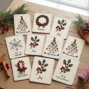 Könnte beinhalten: Eine Sammlung von neun rechteckigen Stoffkarten mit gestickten Weihnachtsmotiven wie Tannenbäumen, Kränzen, Stechpalmen und Schneeflocken. Jede Karte zeigt festliche Schriftzüge wie Merry Christmas, Joy, let it SNOW und happy HOLIDAYS.