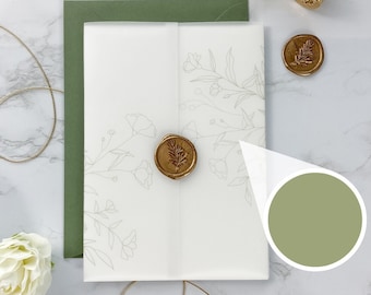 Op de afbeelding: Een witte envelop met een groene rand en een wit binnenblad met een delicaat bloemenpatroon. De envelop is verzegeld met een gouden waszegel met een bladerenontwerp.