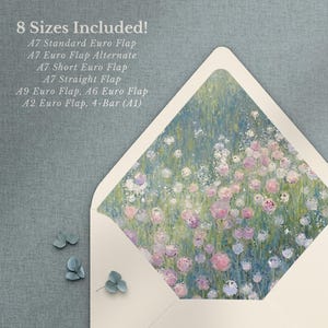 Könnte beinhalten: Ein weißer Umschlag mit einem floralen Design auf der Innenseite des Klappdeckels. Das Design zeigt ein Feld mit rosa, lila und blauen Blumen auf grünem Hintergrund. Der Umschlag liegt flach auf einer blauen Oberfläche.