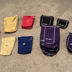 Puede incluir: Surtido de bolsas de cord&oacute;n en varios colores, incluyendo beige, rojo, negro, azul y morado. Algunas bolsas tienen el texto "Crown Royal" impreso en ellas.