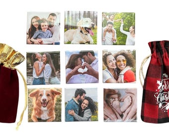May include: A collection of personalized square photo tiles featuring family, pets, and couples. Includes a burgundy velvet gift bag with a gold drawstring and a red and black plaid bag with "Merry Christmas" text.