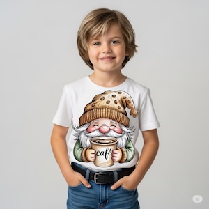 May include: White t-shirt featuring a cartoon gnome wearing a brown knit hat with coffee beans and holding a coffee cup. The cup has the word "café" printed on it. The gnome has a long white beard and is smiling.