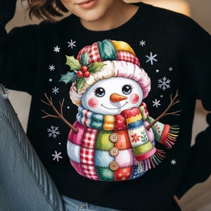 Peut inclure: Pull noir avec un motif de bonhomme de neige fantaisiste. Le bonhomme de neige a un corps en patchwork, un nez en carotte et une écharpe et un chapeau colorés. Des flocons de neige et des étoiles entourent le bonhomme de neige, créant un thème hivernal festif.