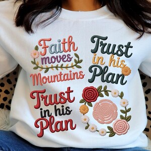 Peut inclure: Sweat-shirt blanc avec texte brodé et motifs floraux. Le texte comprend des phrases telles que "Faith moves mountains" et "Trust in his Plan". Le design présente diverses couleurs, dont le rouge, le rose, le vert et le jaune, avec une couronne de fleurs.